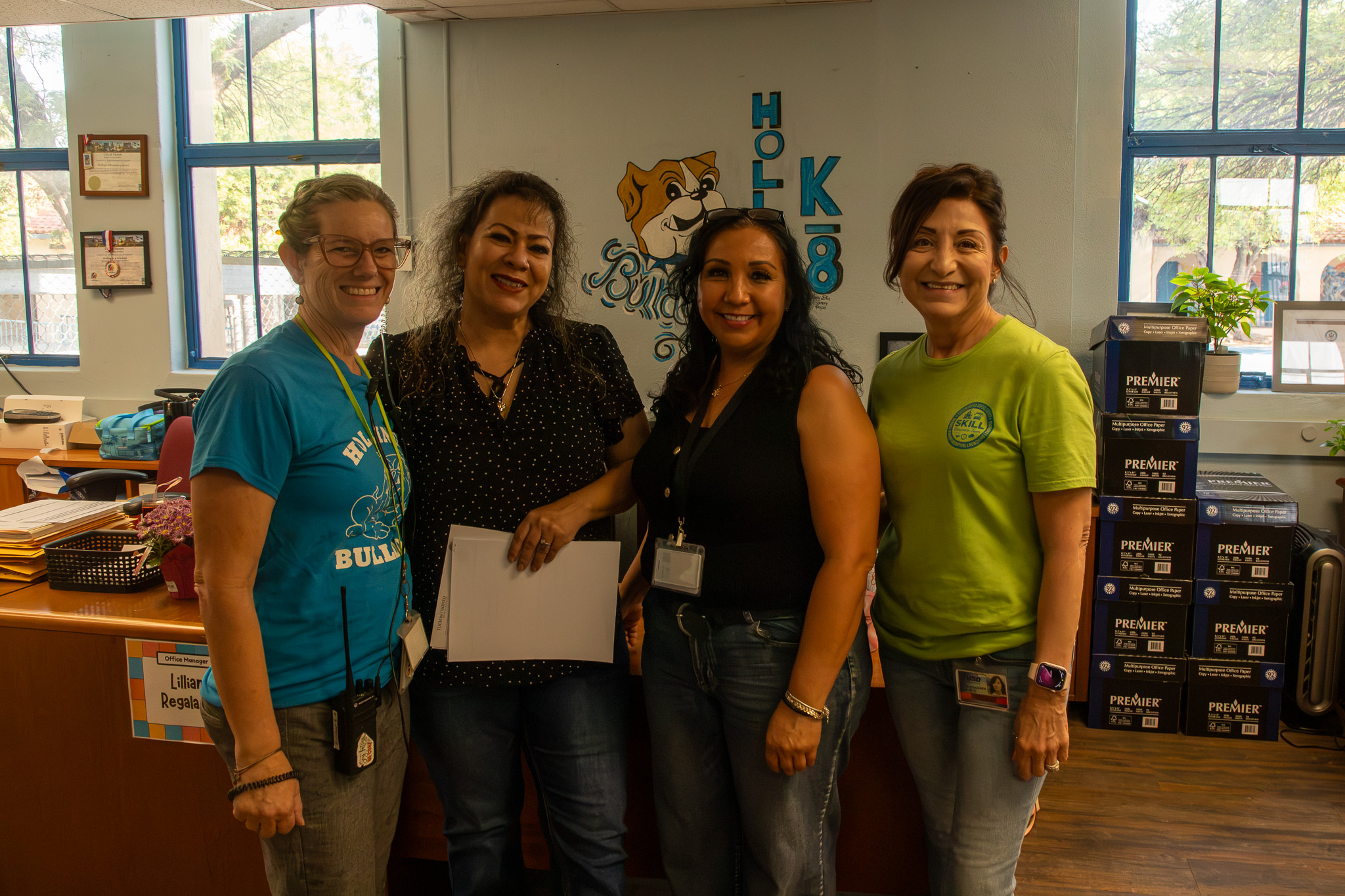 Four women from the front office smile for a photo