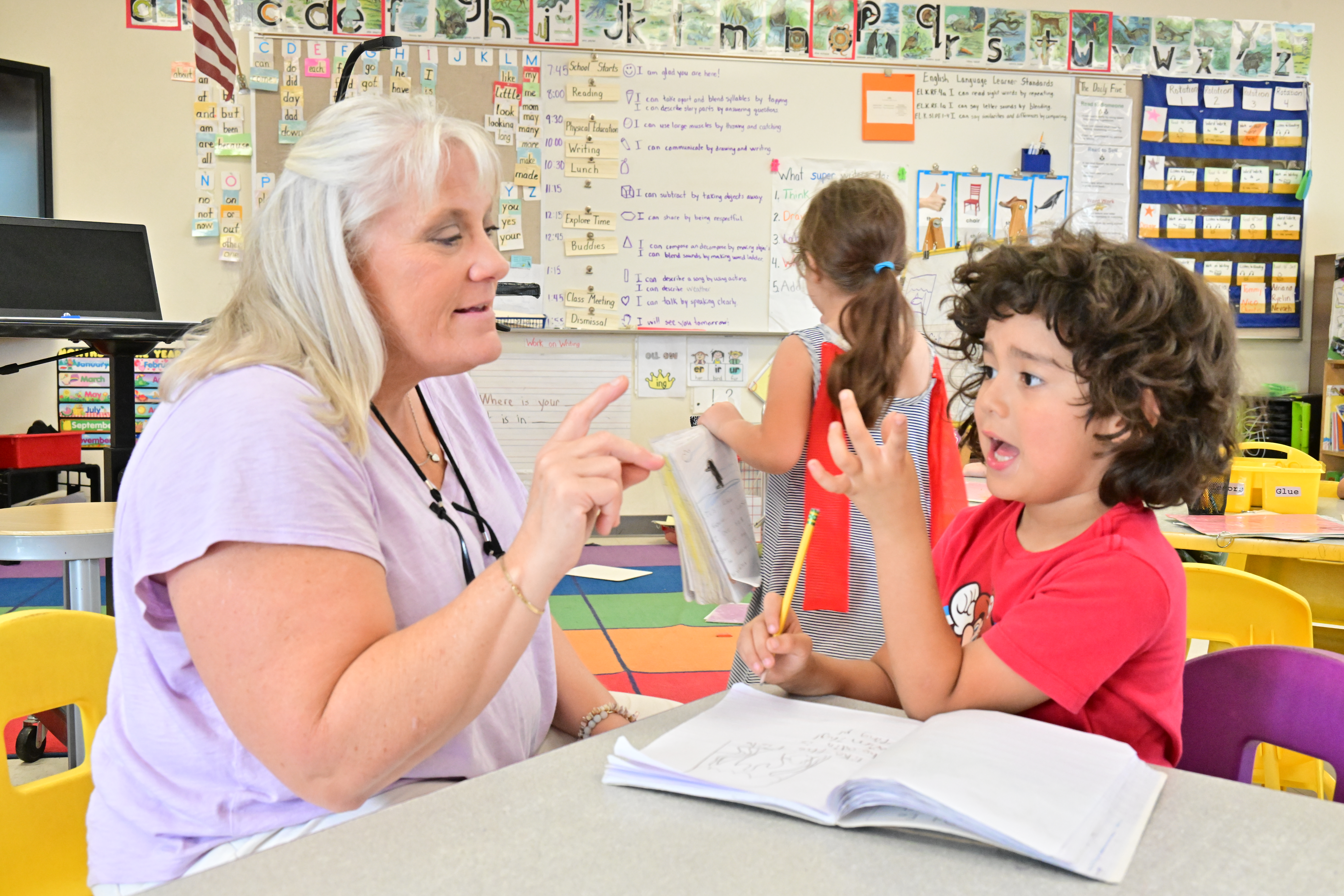 A teacher works with one of her students on counting