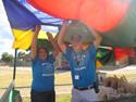 people waving a rainbow parachute